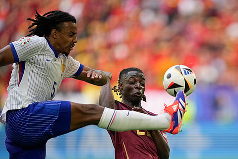 Jules Kounde  and Jeremy Doku fight for the ball